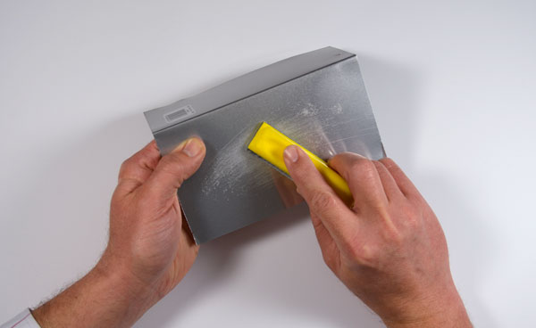 Hand sanding on the metal