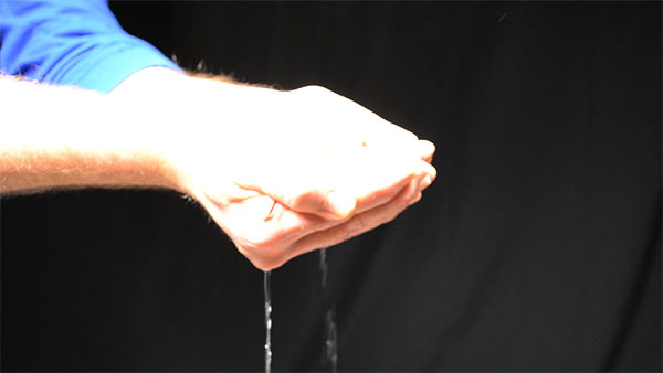 hands holding some water under lights with a regular shutter speed of about 1100